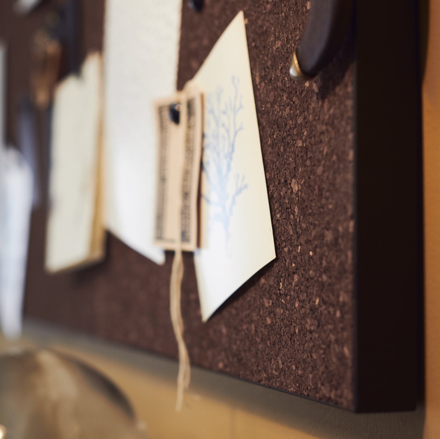 لوحة ملاحظات SVENSÅS مصنوعة من الخشب المضغوط والفلين، معلَّق عليها العديد من المواد الورقية.