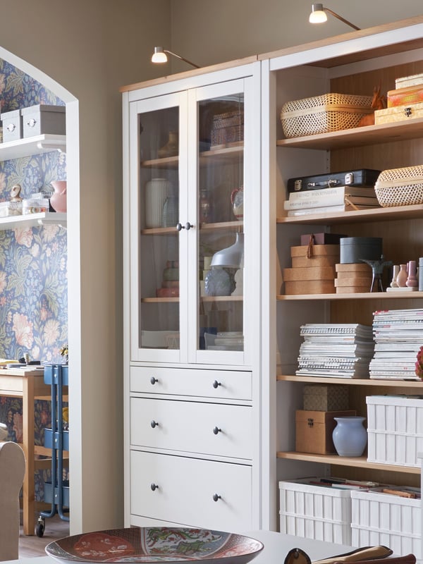 A white stain/light brown HEMNES glass-door cabinet with 3 drawers in the living room