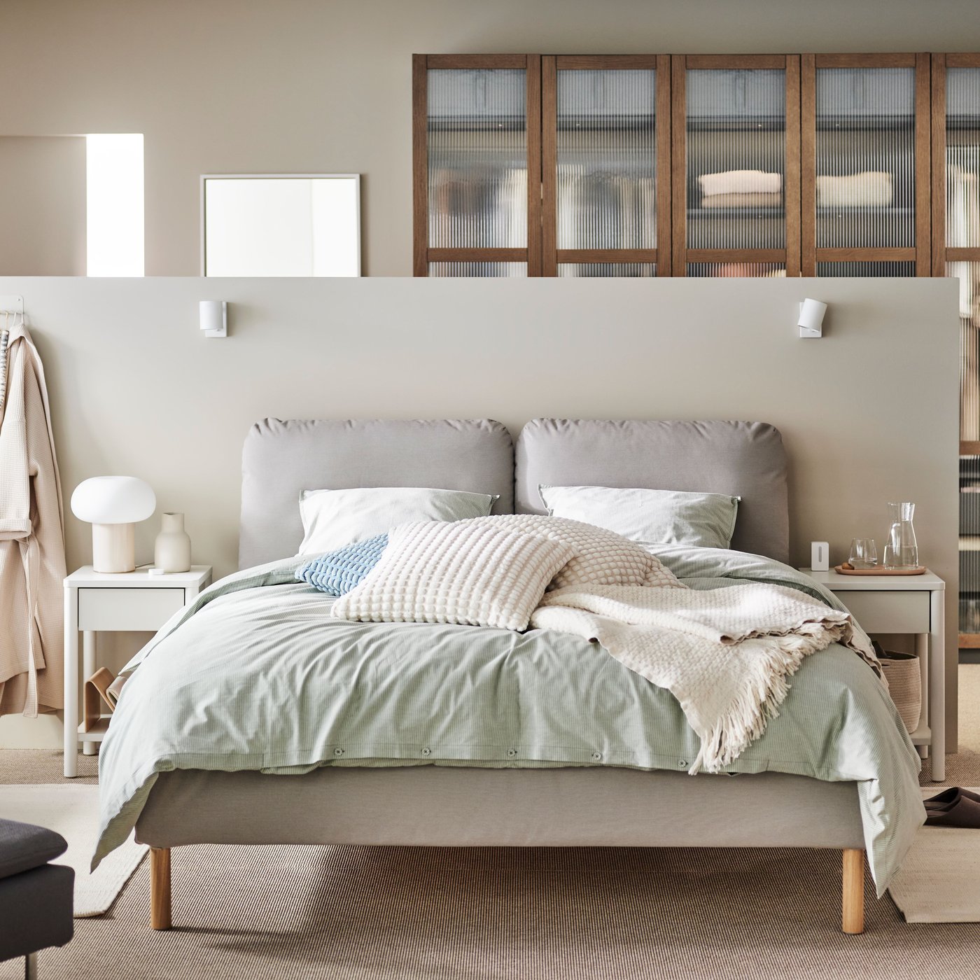 Lit double dans une chambre parentale avec séparation devant un dressing