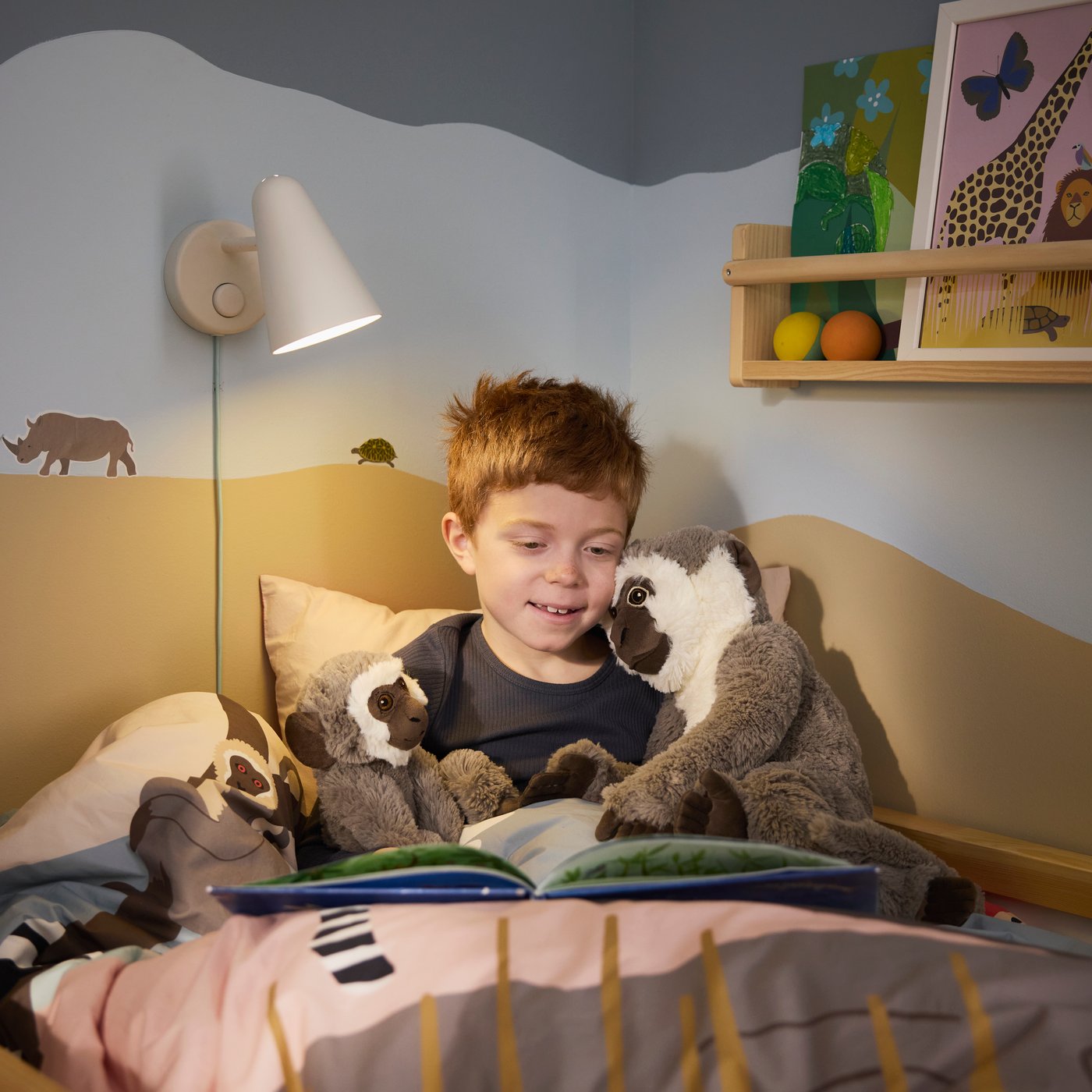 Ein Kind liegt gemütlich in einem IKEA Bett mit Leselicht, umgeben von Kuscheltieren. Das Kinderzimmer ist liebevoll eingerichtet mit Spielzeug und Bücherkiste – ein perfekter Rückzugsort zum Lesen und Träumen von fernen Welten.