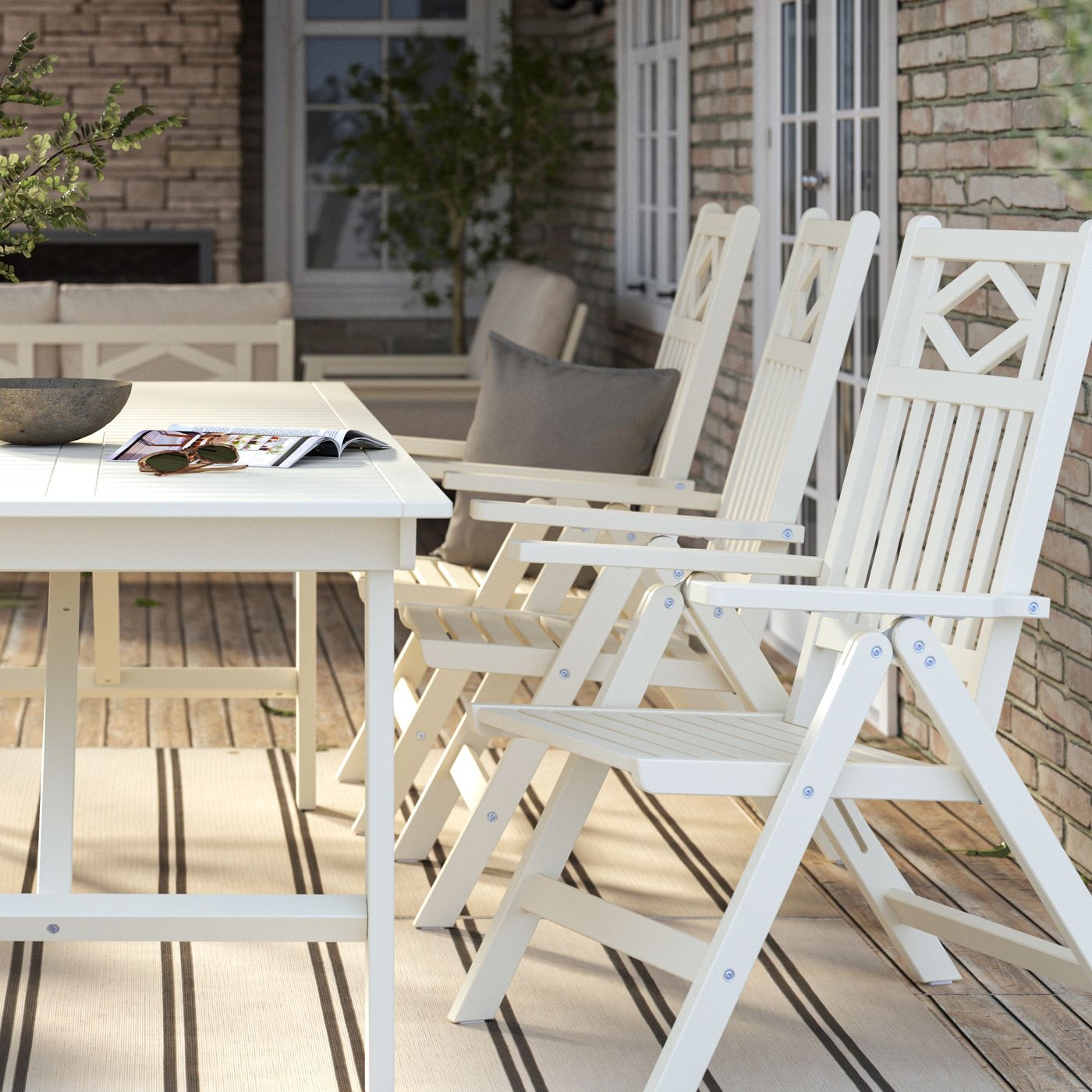 Utemöbler med beige/vita positionsstolar och matchande bord.