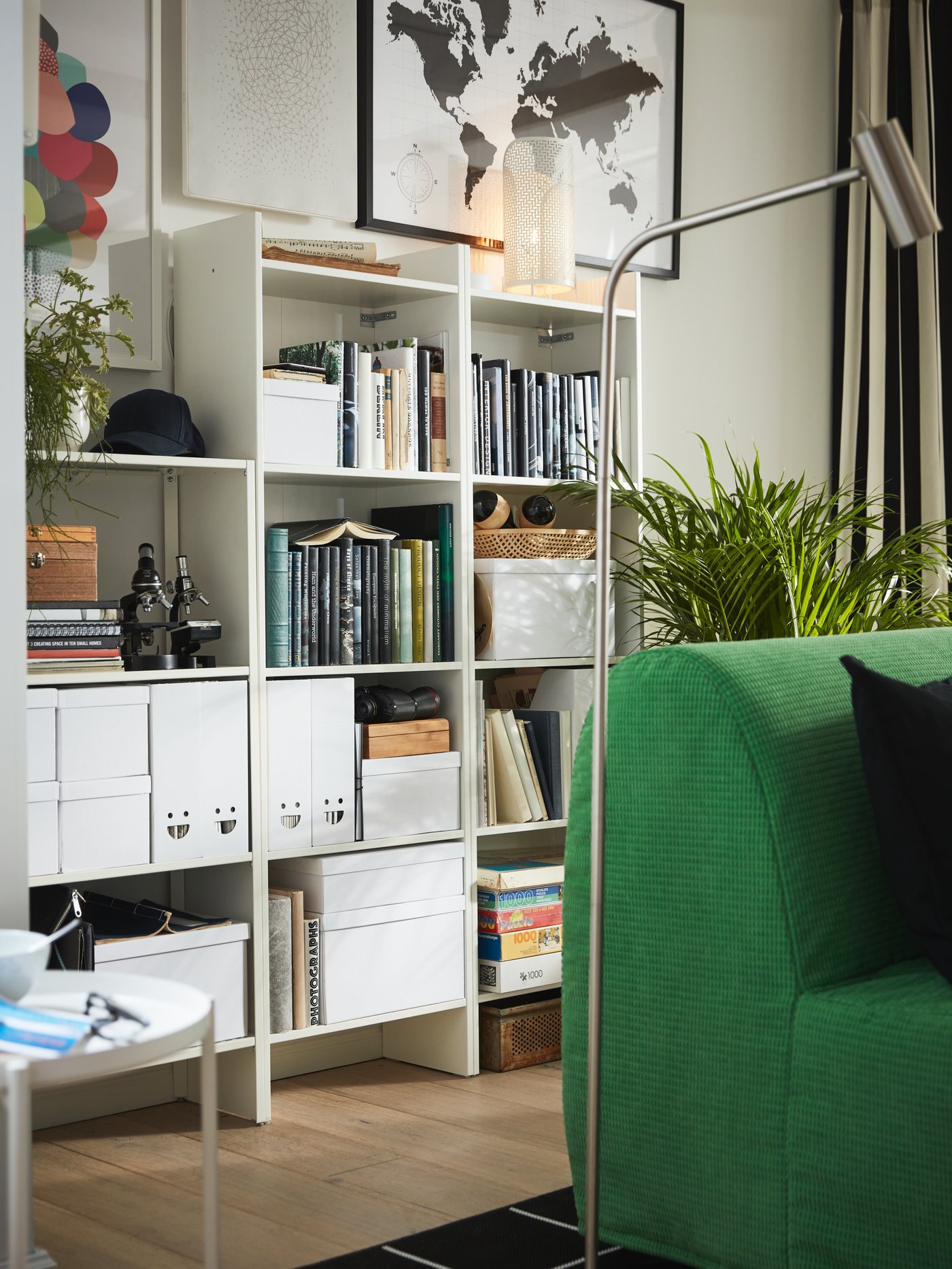 Living con una librería blanca de aglomerado que almacena varias cajas de almacenaje rectangulares con tapa.