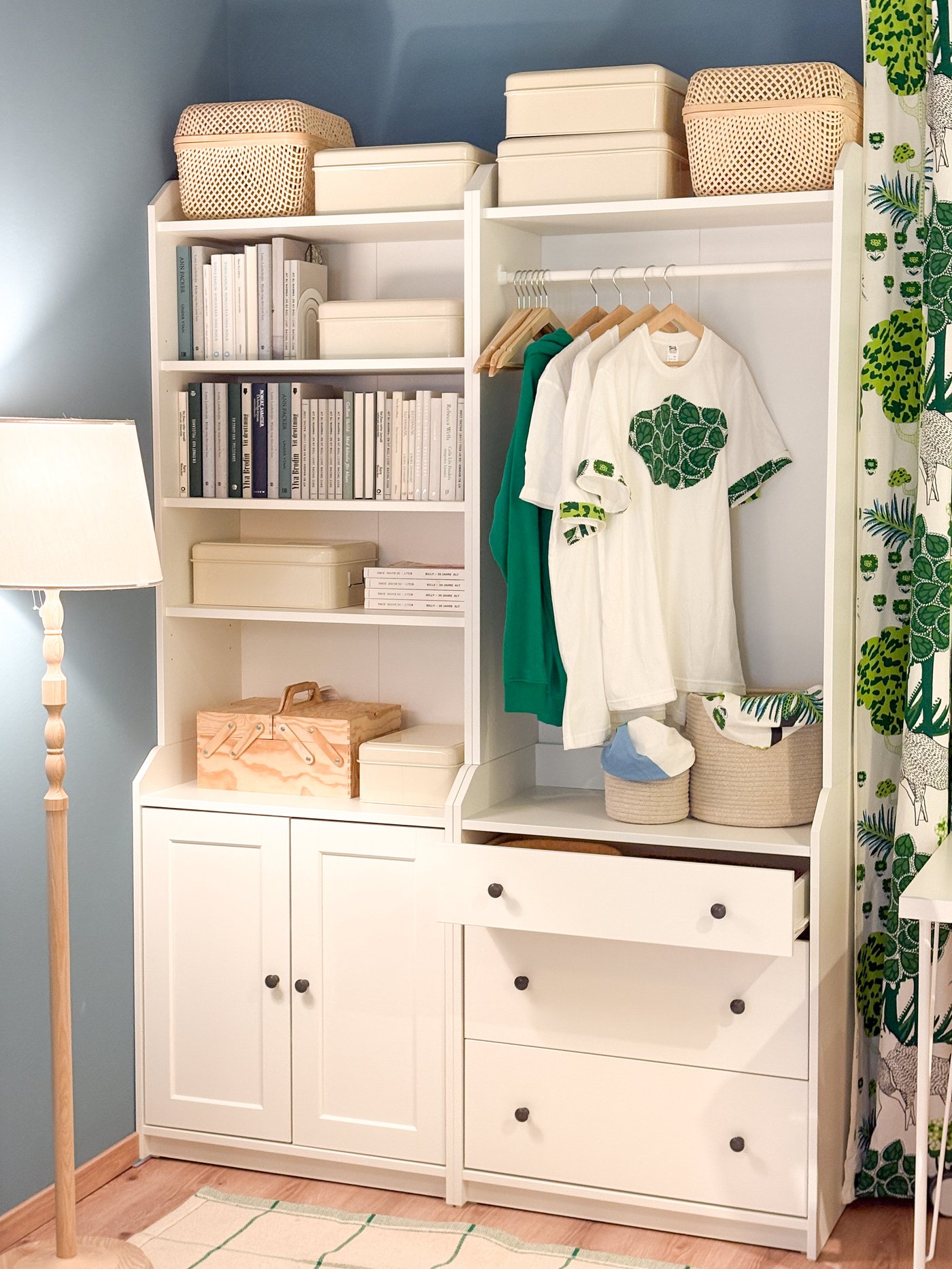 Ein weißer Schrank steht vor einer Wand in Grün und Weiß