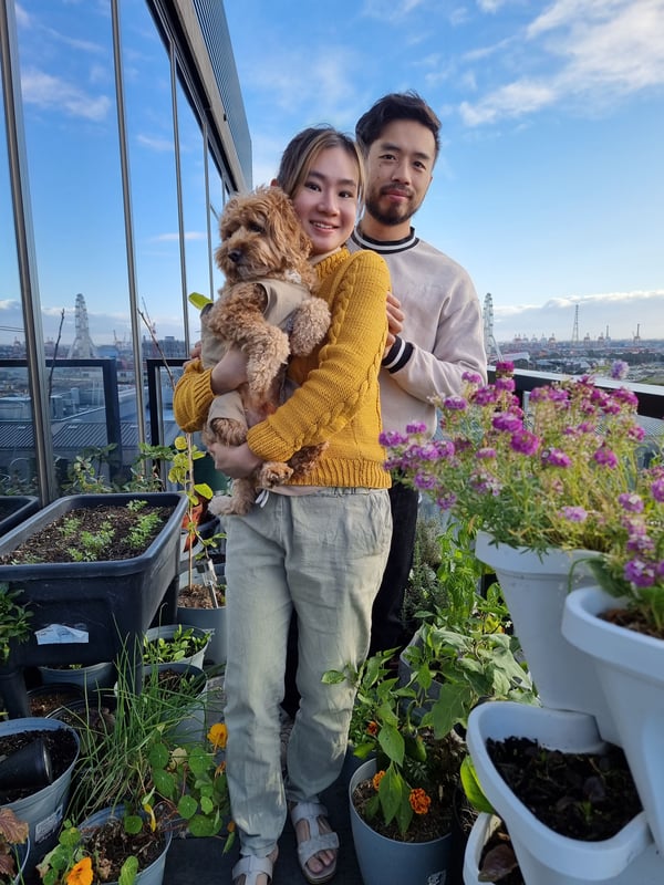 Cheng Yee, her fiancé and her dog posing with their plants in their balcony garden.