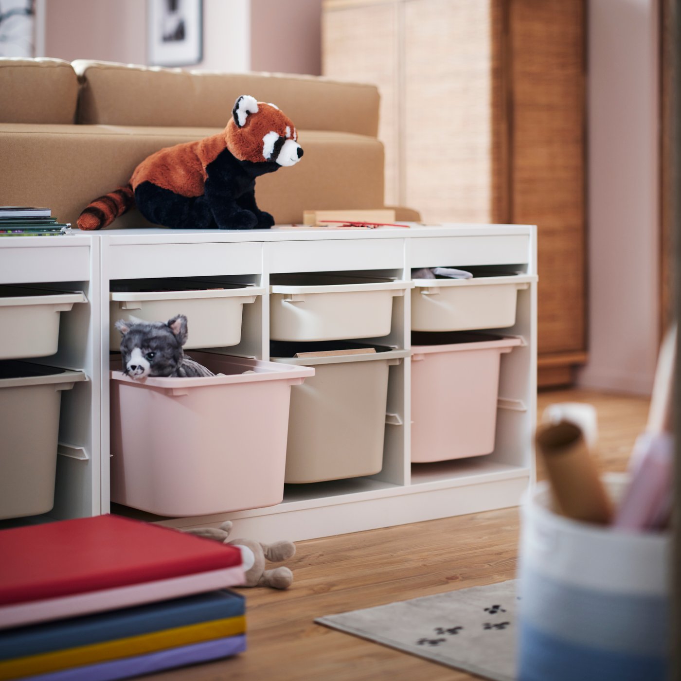 TROFAST boxes arranged in a TROFAST frame with toys, books and soft toys in a children’s play area.