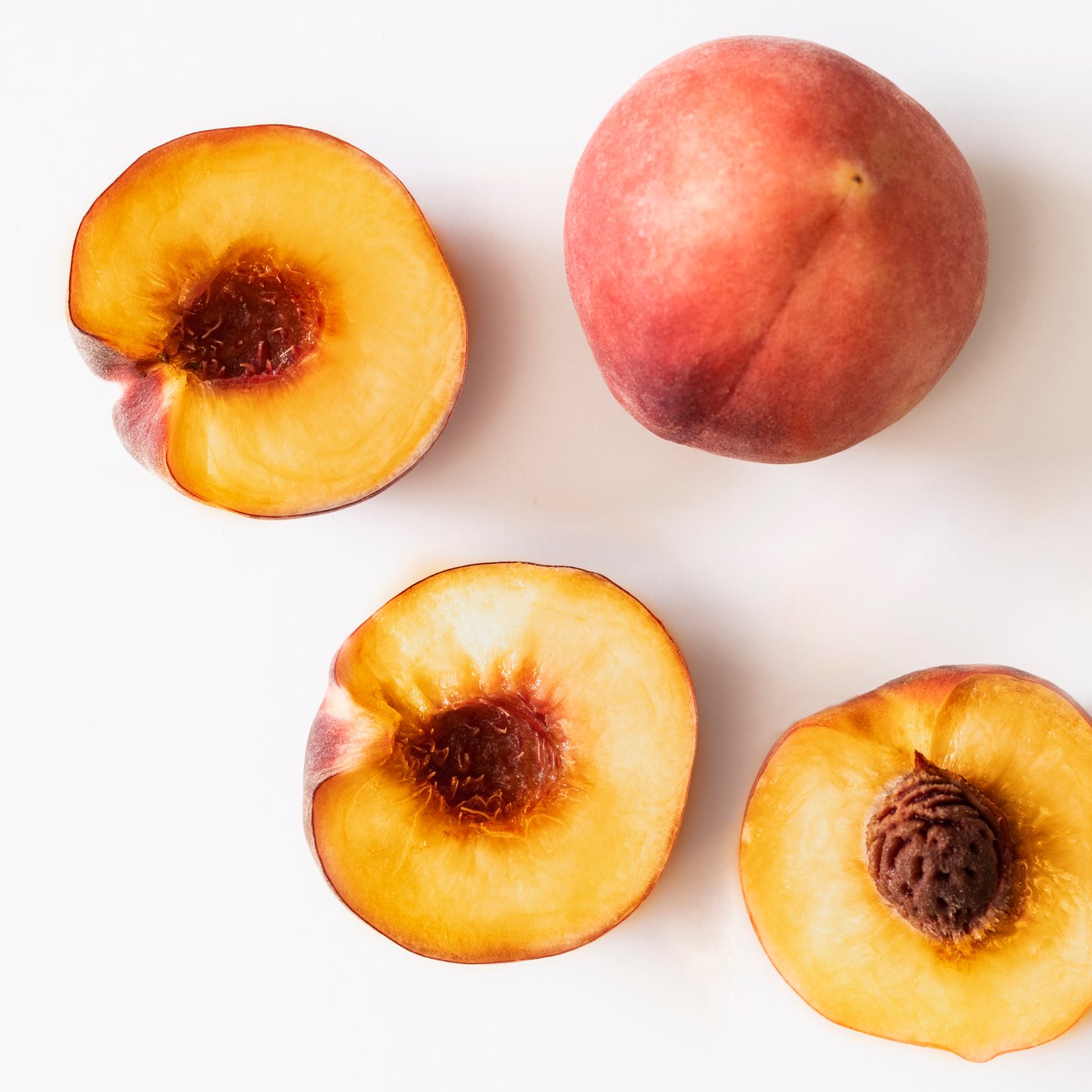 A Peach light orange LOTSFÅGEL scented candle in glass