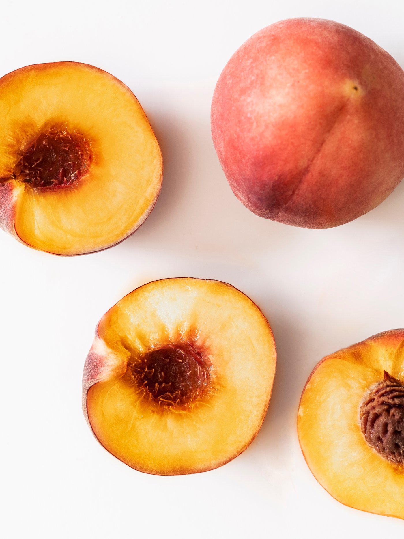 A Peach light orange LOTSFÅGEL scented candle in glass