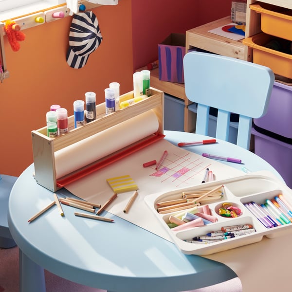 Una habitación infantil con un set MAMMUT con mesa y sillas de plástico.