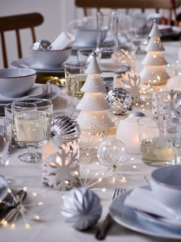 Un tavolo perfetto per le feste, dai colori bianco e argento, con le decorazioni natalizie della linea VINTERFINT e le magiche atmosfere delle luci STRÅLA.