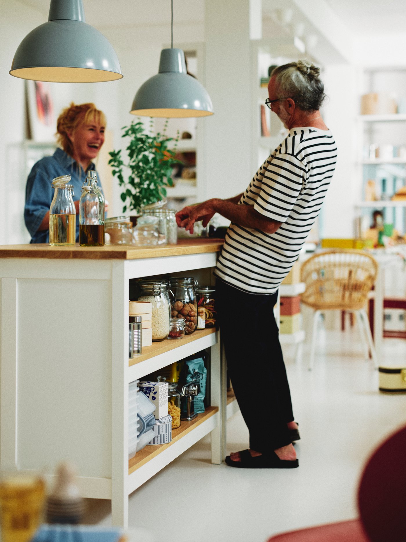 2 people having a good time in dining room across the kitchen counter 