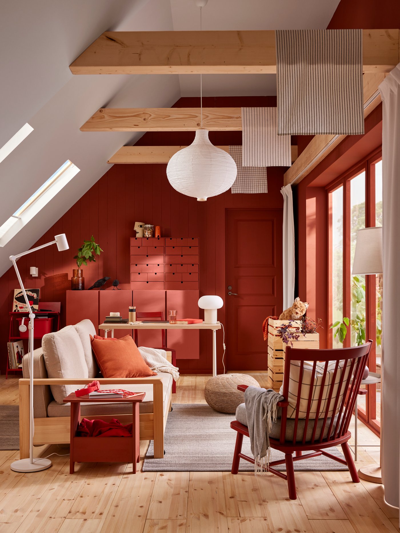 A TORNSBORG sofa-bed and a PERSBOL armchair stand in a family room with a TIDTABELL rug underneath a RISBYN pendant lamp.