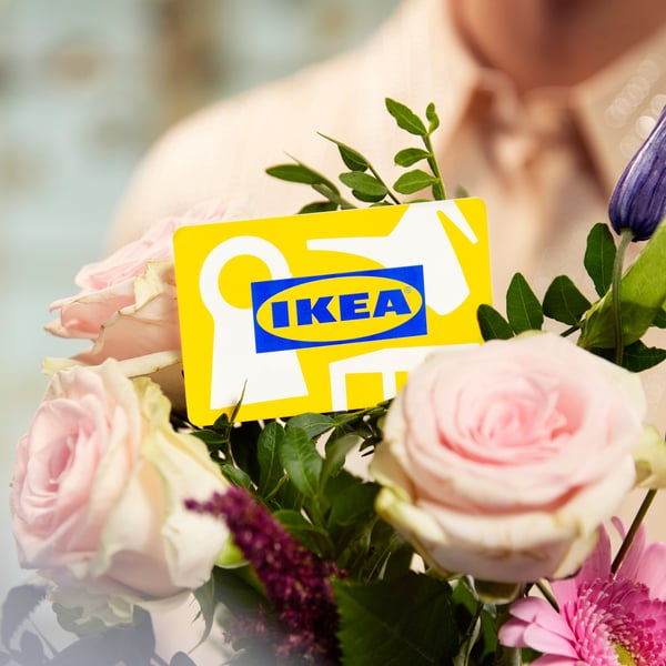 IKEA-lahjakortti kukkakimpussa vaaleanpunaisten ruusujen keskellä.