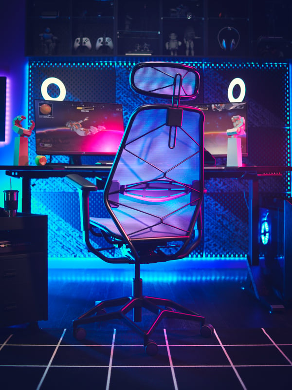 An IKEA STYRSPEL chair from the back against a gaming desk with blue accent lighting. 