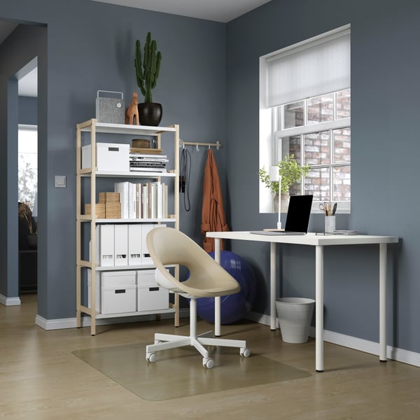 Desk with white top and legs, with a white swivel chair and a white shelving unit with white filing boxes and boxes,