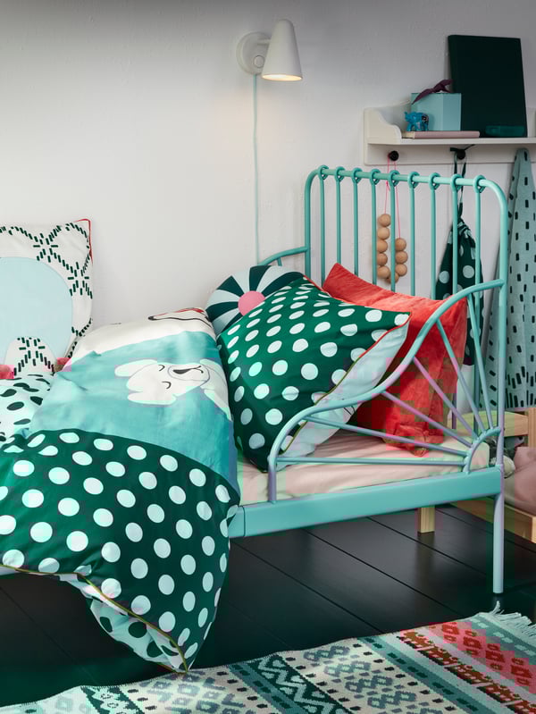 An extendable bed frame in turquoise and KÄPPHÄST printed bed linen in turquoise, green and white.