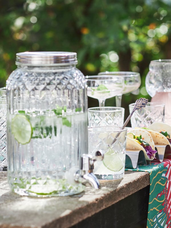 The top of a rough cement structure laden with a water-filled KALASFINT glass jar, with STORHET coupes and tacos.