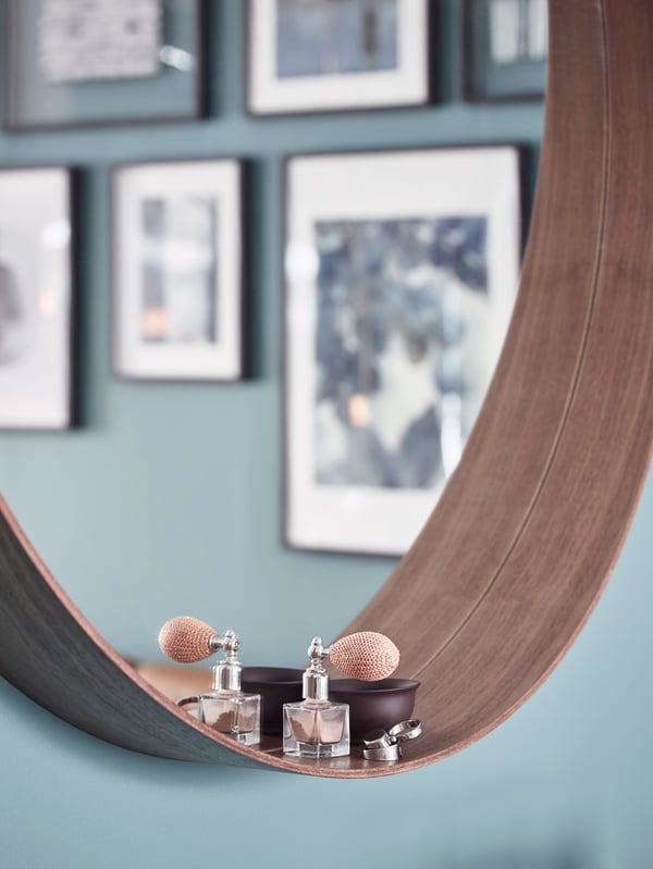 Close-up of STOCKHOLM mirror’s deep ledge, holding a small perfume bottle.