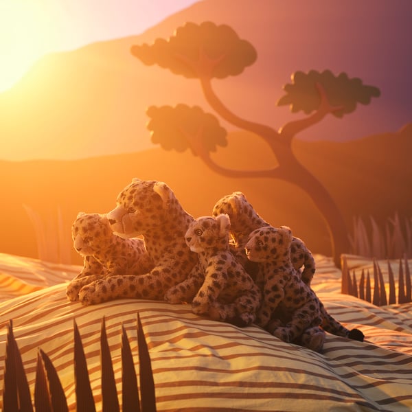 Peluches bébé guépard/beige SANDLÖPARE à l’extérieur dans un décor de savane.