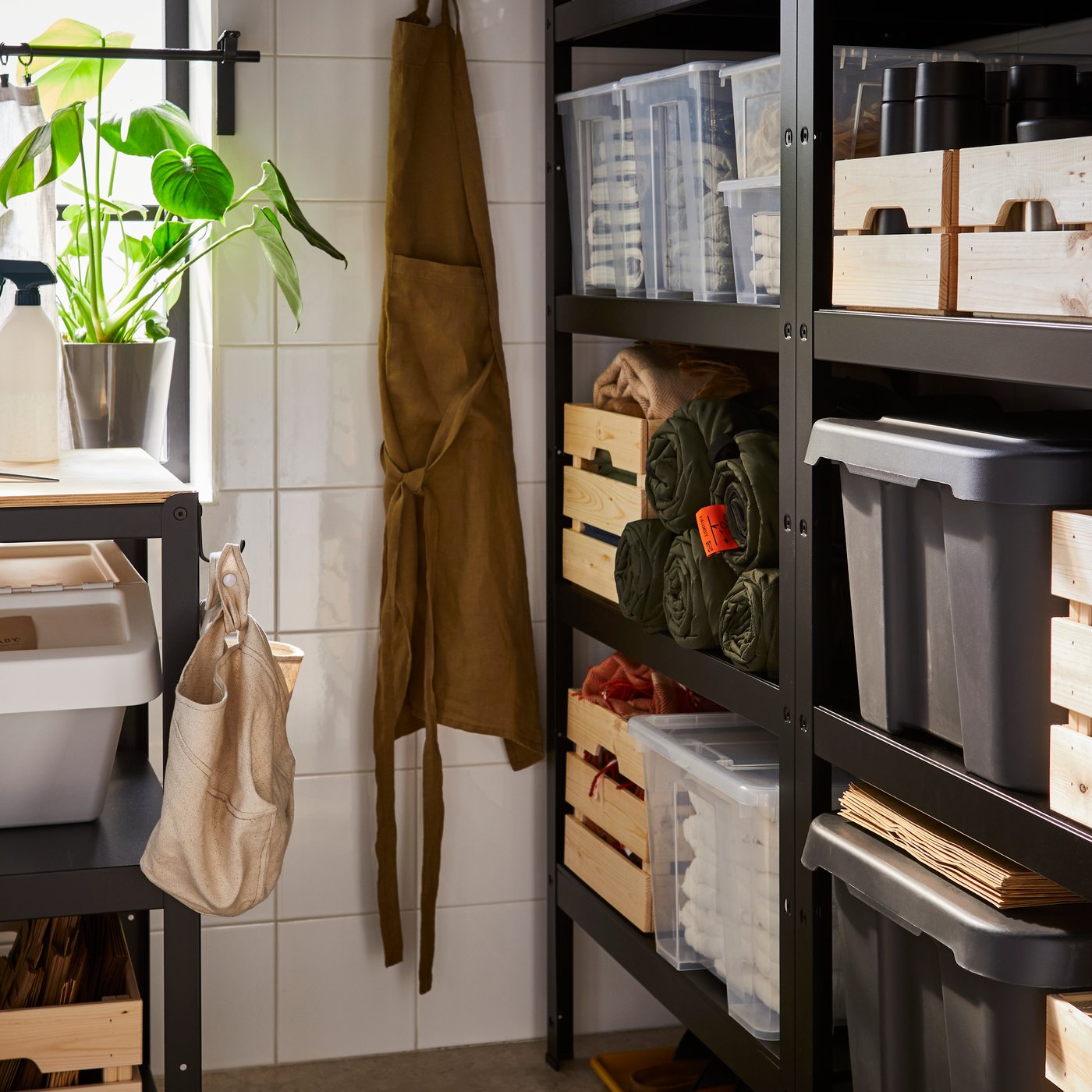 A storage room with black BROR shelving units against one wall and a BROR work bench against another wall under a window.