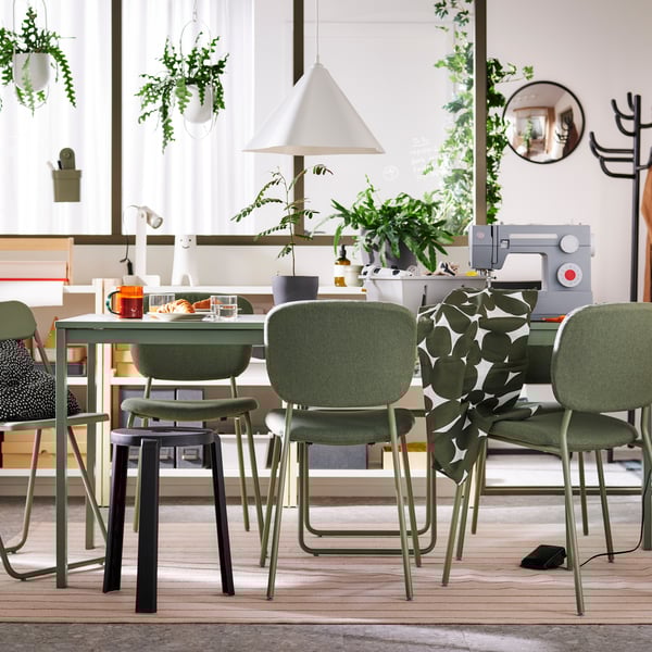 VIHALS chairs and a stool stand at a green VIHALS extendable table on a rug in a multifunctional dining room.