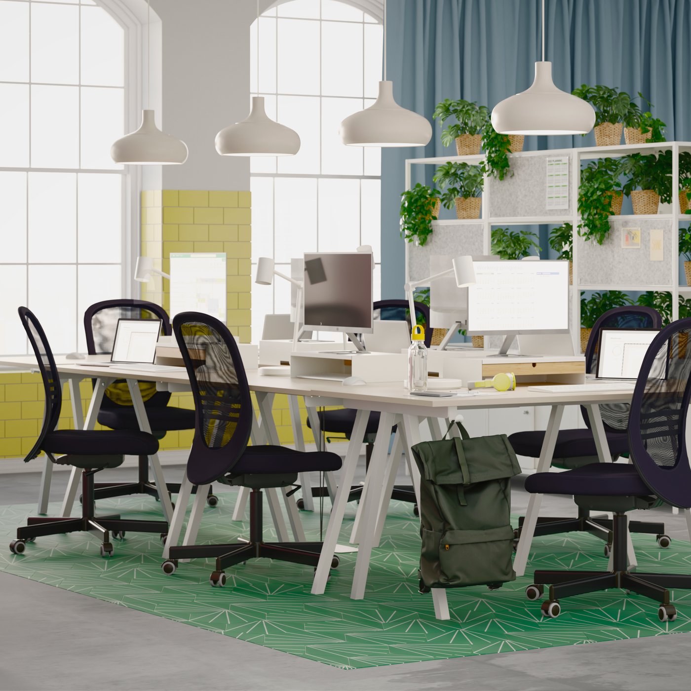 A light, airy office with several black FLINTAN office chairs around a cluster of TROTTEN desks, forming a shared workspace.