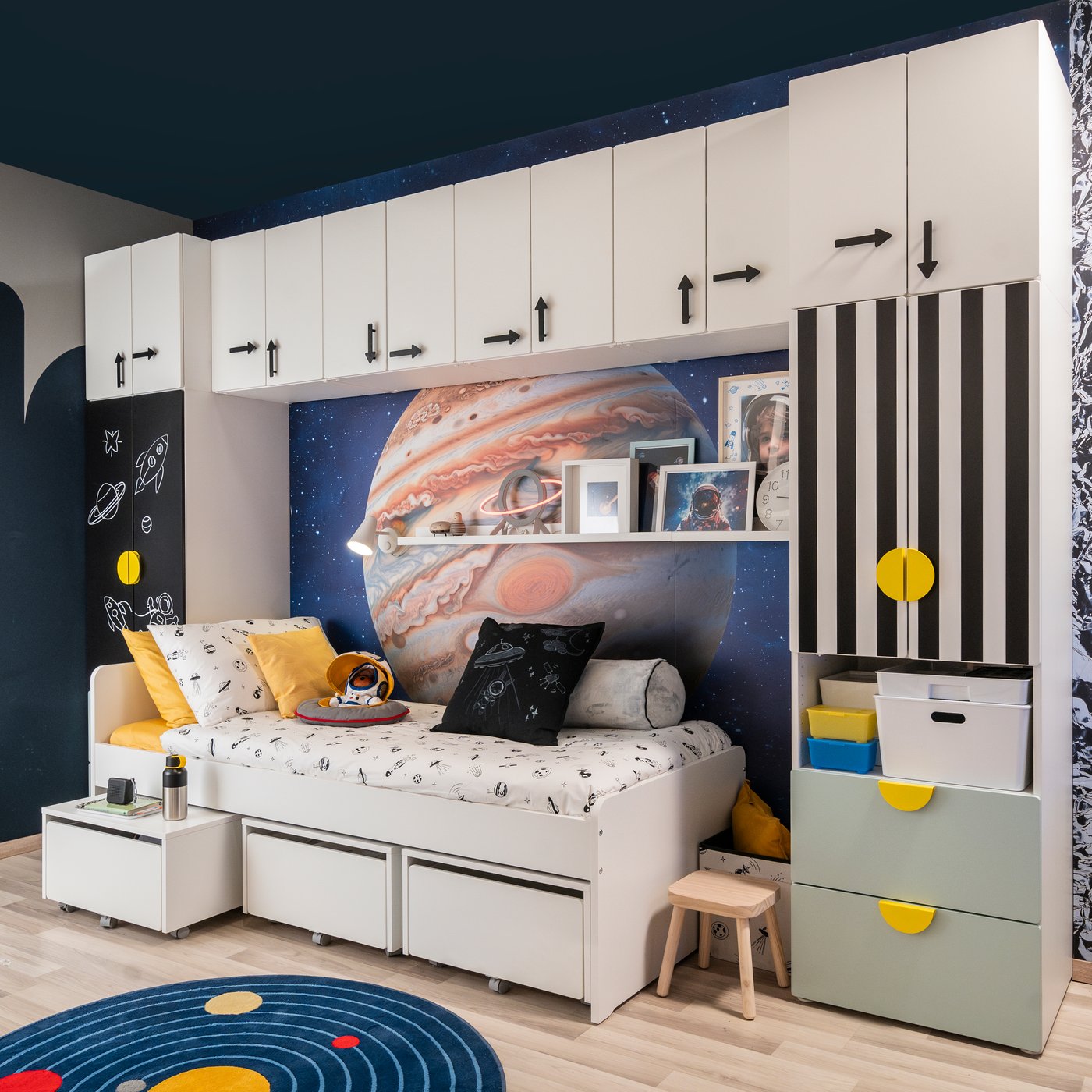 Una soluzione di cameretta con mobili a ponte con mobili componibili della serie SMÅSTAD con diverse ante e maniglie e un letto SLÄKT
