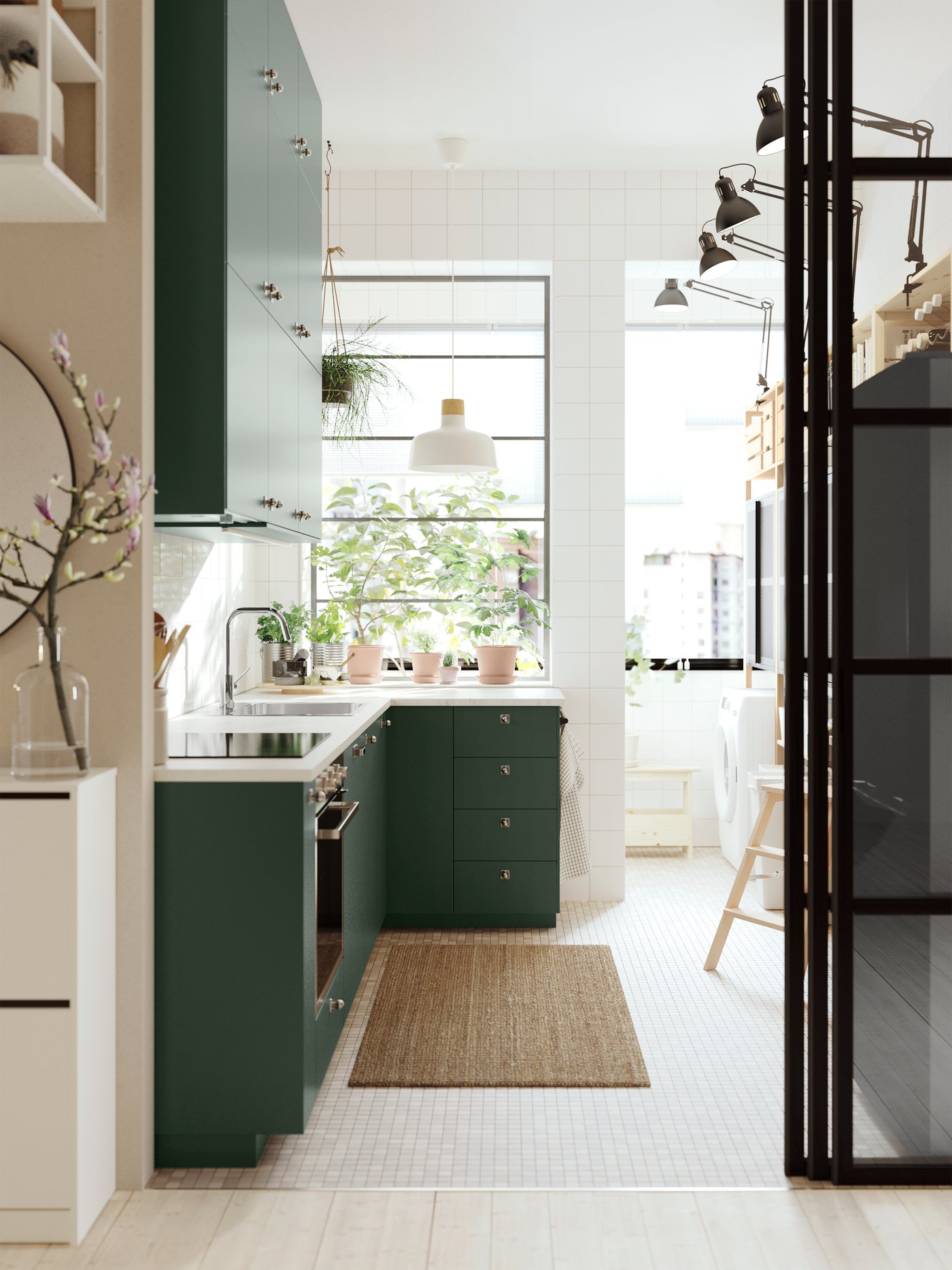 A kitchen with deep green kitchen fronts, a white marble effect/laminate EKBACKEN worktop and a white/birch pendant lamp.