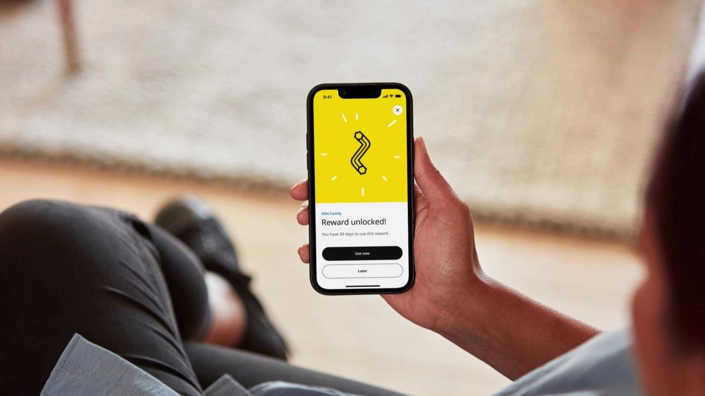 A hand holding a phone up displaying the IKEA app.