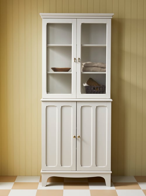 A light beige LOMMARP cabinet with glass doors is on a tiled floor by a panelled wall. Baskets are visible through the glass.