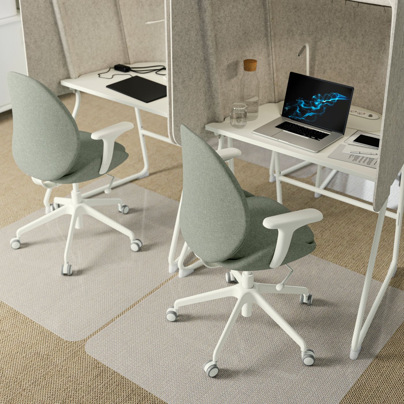 Four cocoon-like shaped MITTZON focus workstations grouped together in a small office and two green chairs on castors.