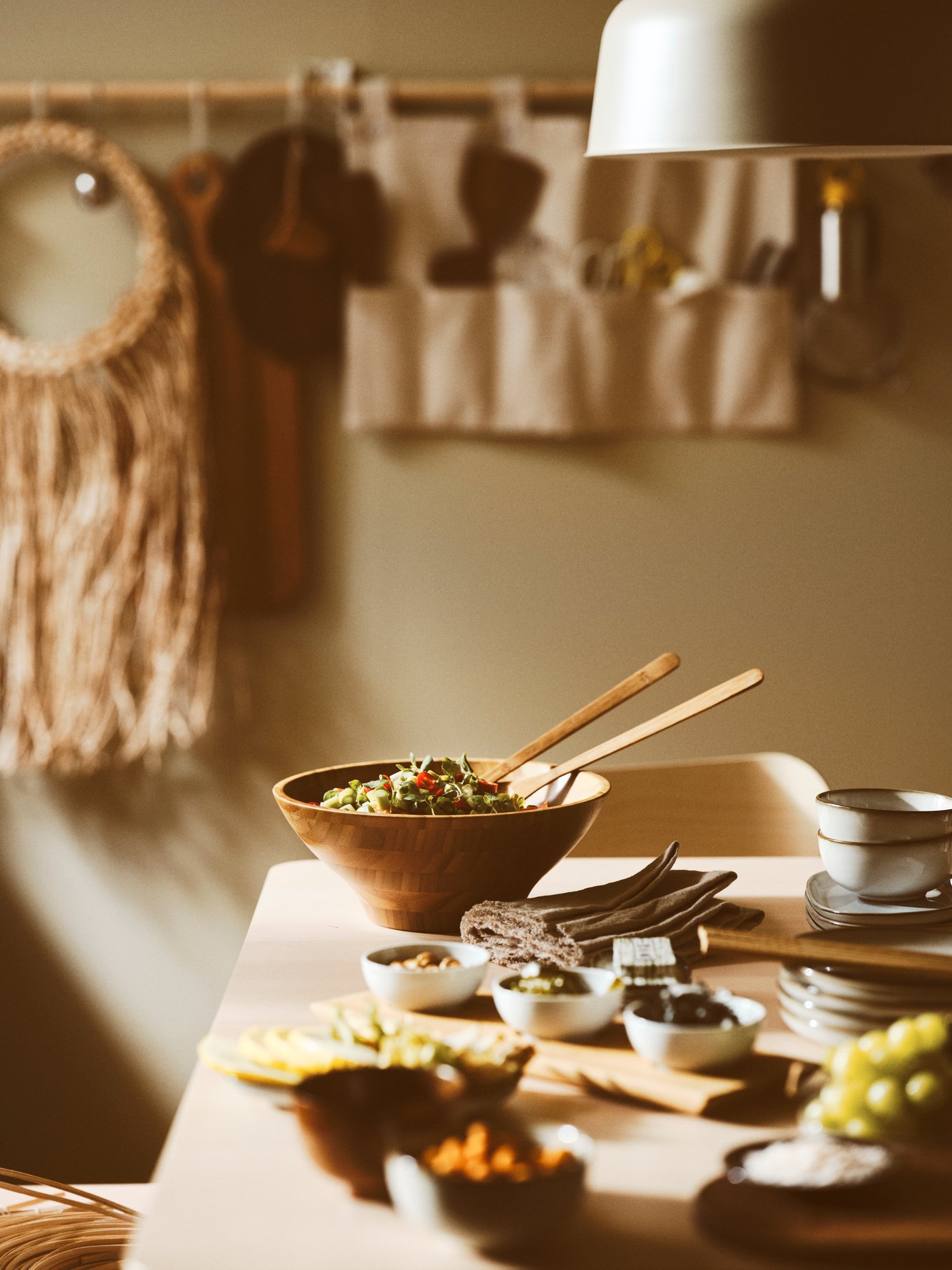 Sobre una mesa reposan un bowl para servir GRÖNSAKER con comida y dos ensaladeras GRÖNSAKER junto a una bandeja con tres bowls.