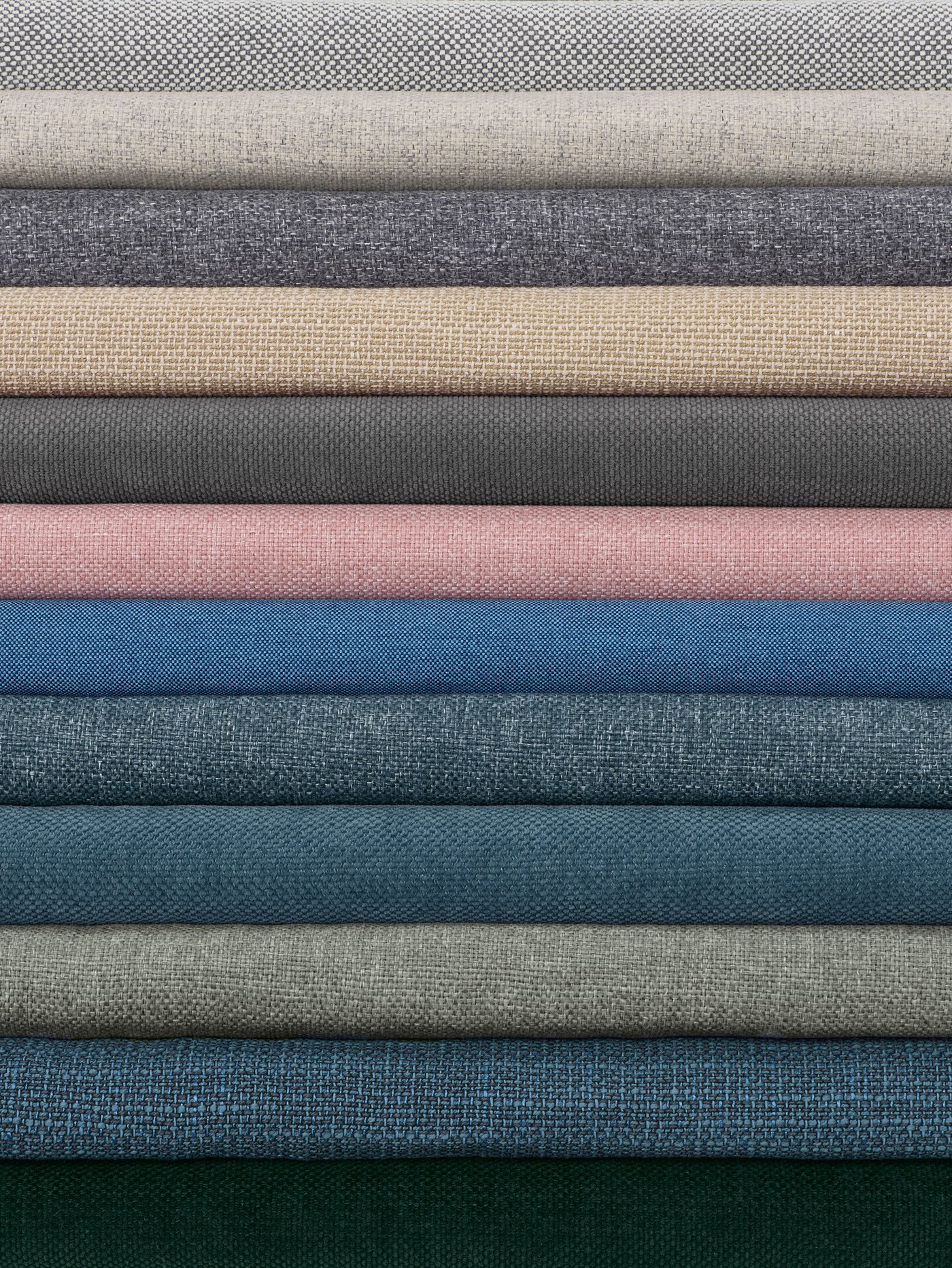 A stack of IKEA+ sofa covers in a variety of colours. Order your IKEA+ sofa cover and it will be made on demand.
