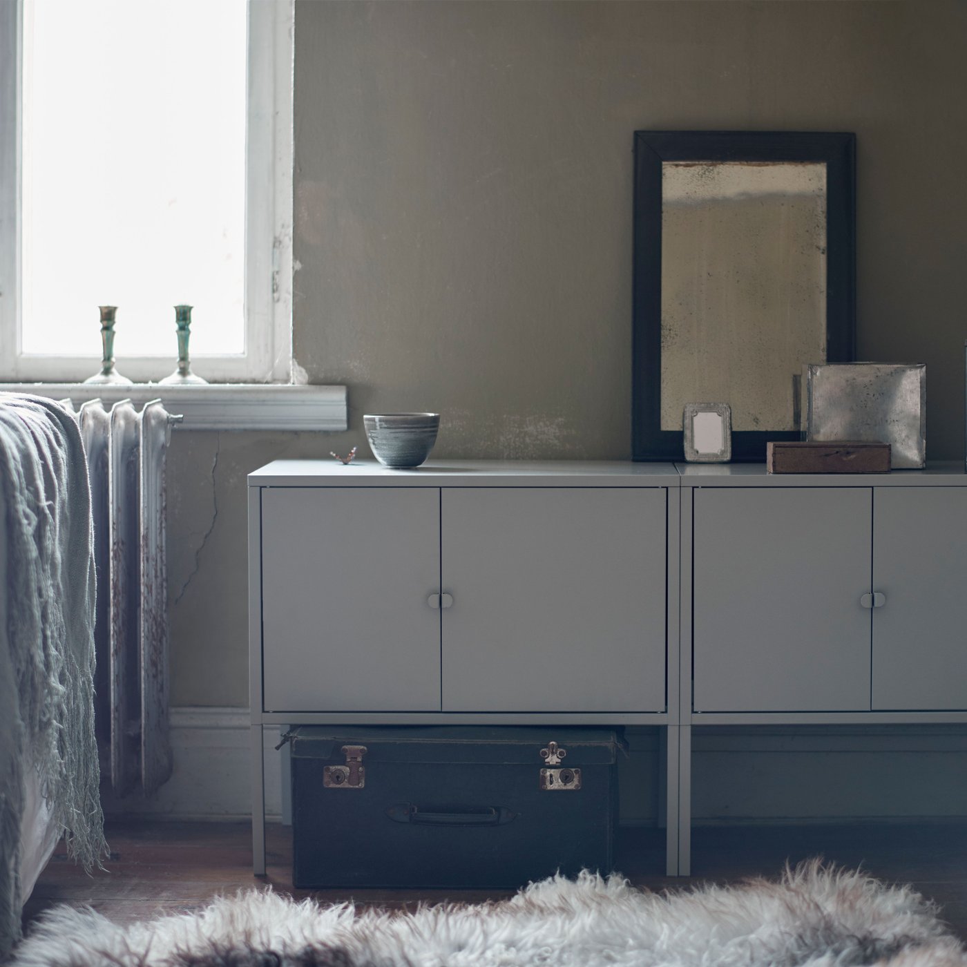 Two grey LIXHULT metal cabinets stand side by side against a wall, with minimal decorative items on top.