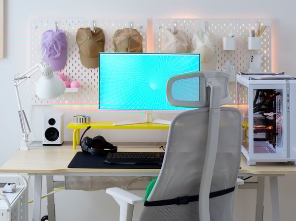 A bright, airy and tidy UTESPELARE ash effect gaming desk has two white SKÅDIS pegboards on the wall behind a monitor.