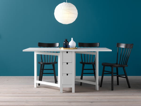 Una mesa extensible NORDEN con 3 sillas negras.