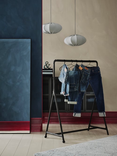 Hallway featuring a black TURBO clothes rack for indoor and outdoor use, placed next to a rectangular HOVET mirror.