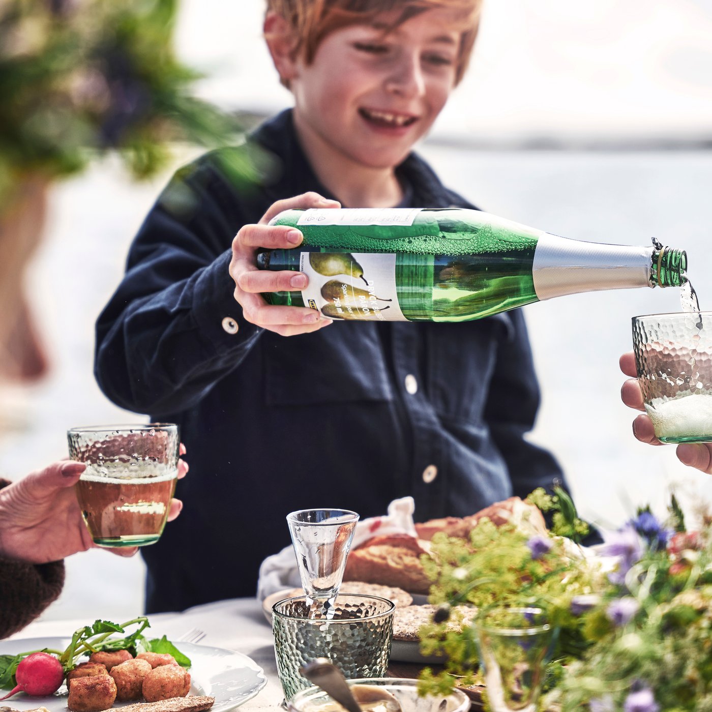 Young boy pouring pear sparkling drink
