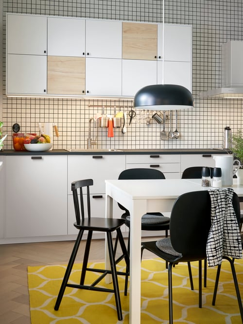 Kitchen with base cabinets with drawers and fronts, wall cabinets, extendable table, pendant lamp, chairs, cooking utensils.