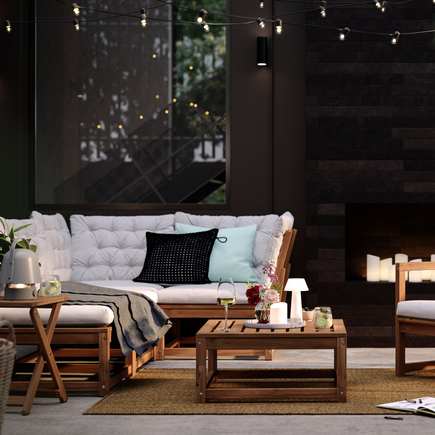 A patio with light brown stained outdoor NÄMMARÖ lounge seating and a seat section for a modular sofa doubling as a table.