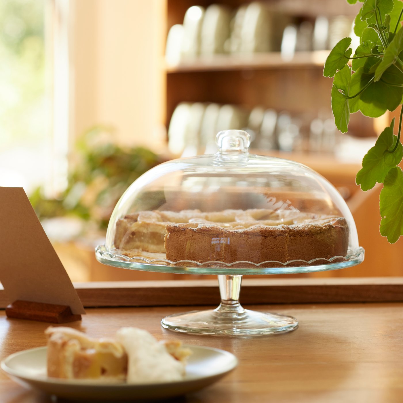 Ciasto na szklanej paterze ARV BRÖLLOP pod przykryciem.