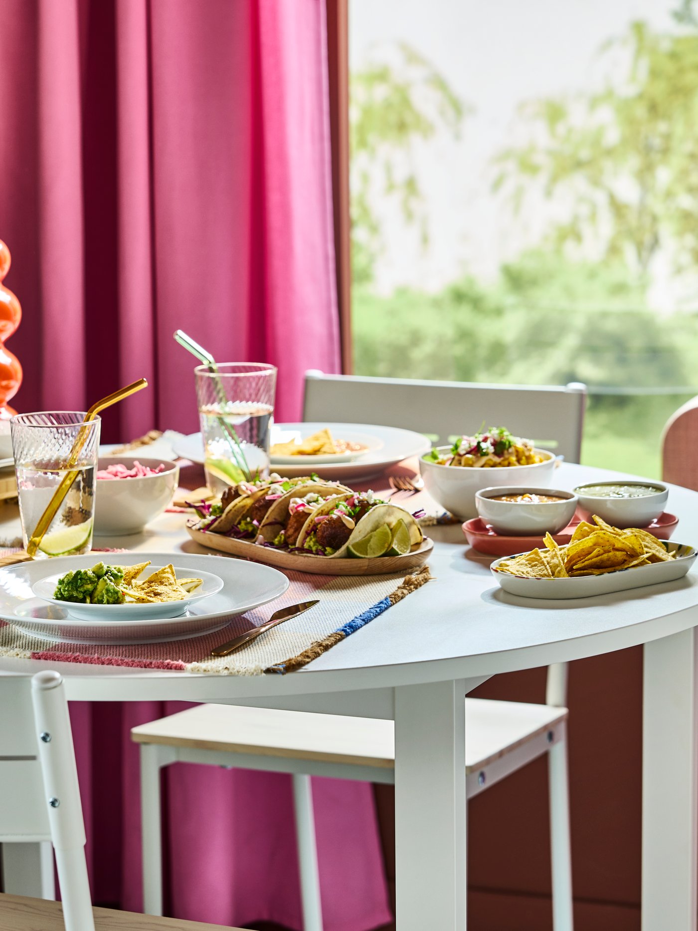Mexican feast on round white VIHALS table with white IKEA 365+ plates, and transparent ripple-effect KLIPPLAX glasses.