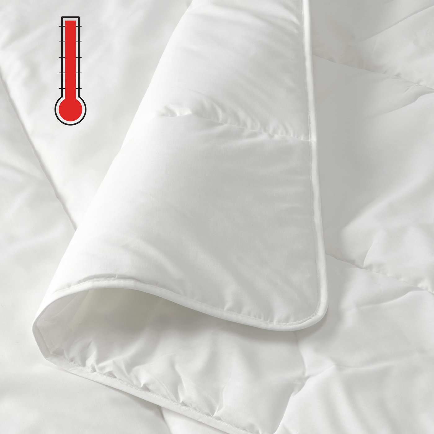 A close-up of a folded white duvet with a red extra-warm temperature symbol in the top left corner.
