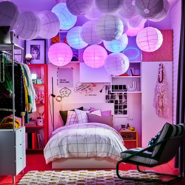 מנורות תלייה REGNSKUR/SUNNEBY תלויות ליד מסגרת מיטה עם ארבעה עמודים VITARNA בצבע לבן. מצעים SYRABLADMAL מונחים על המיטה.