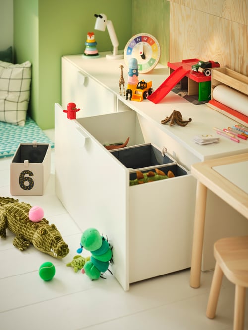 Baby and children room with a rectangular SMÅSTAD box placed next to a FILSAT childrens table and a FILSAT childrens stool.