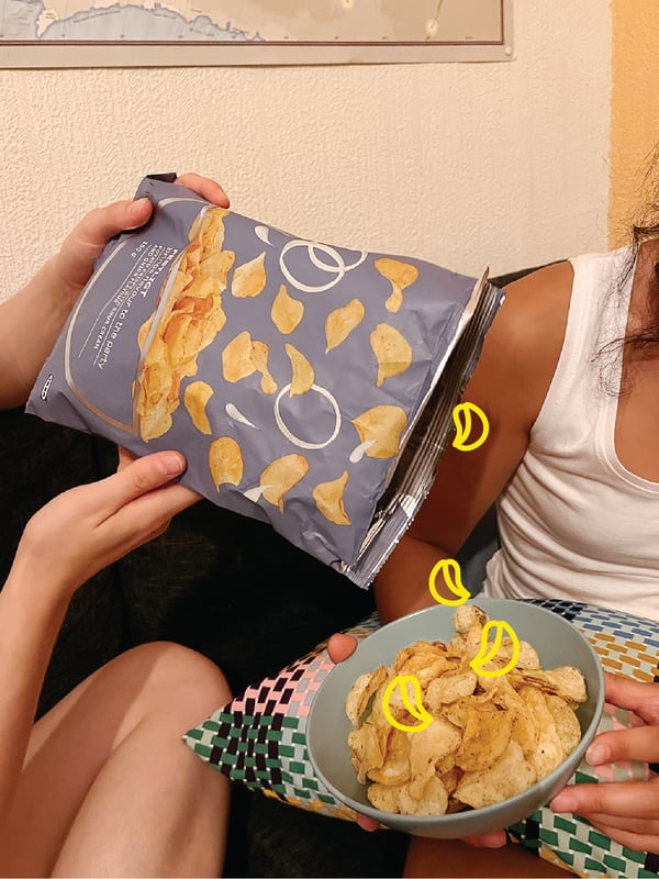 Eine Person kippt FESTLIGT Kartoffelchips in eine Schüssel.