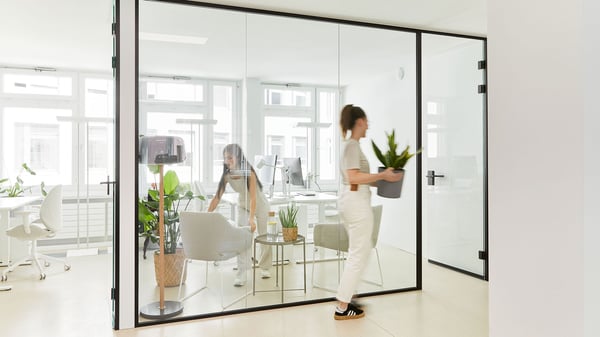 Un poste de travail de bureau avec un bureau, une chaise de bureau à dossier haut et une étagère de bureau avec un espace de rangement pour les documents.