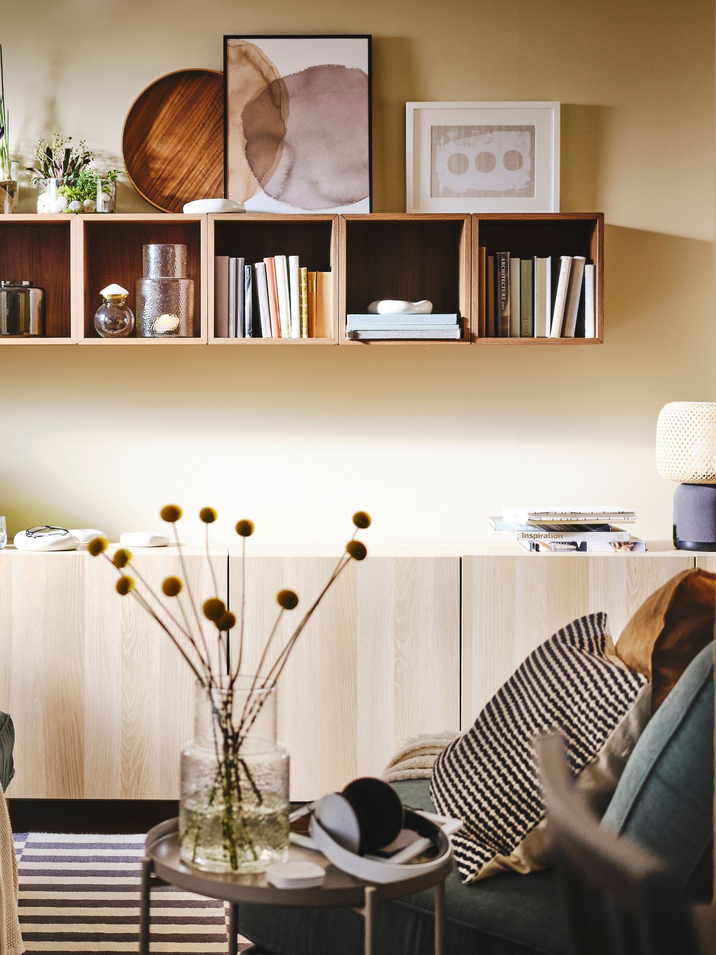 An IKEA BESTA unit in white stained oak with cube storage on the wall above, in a room with beige walls.