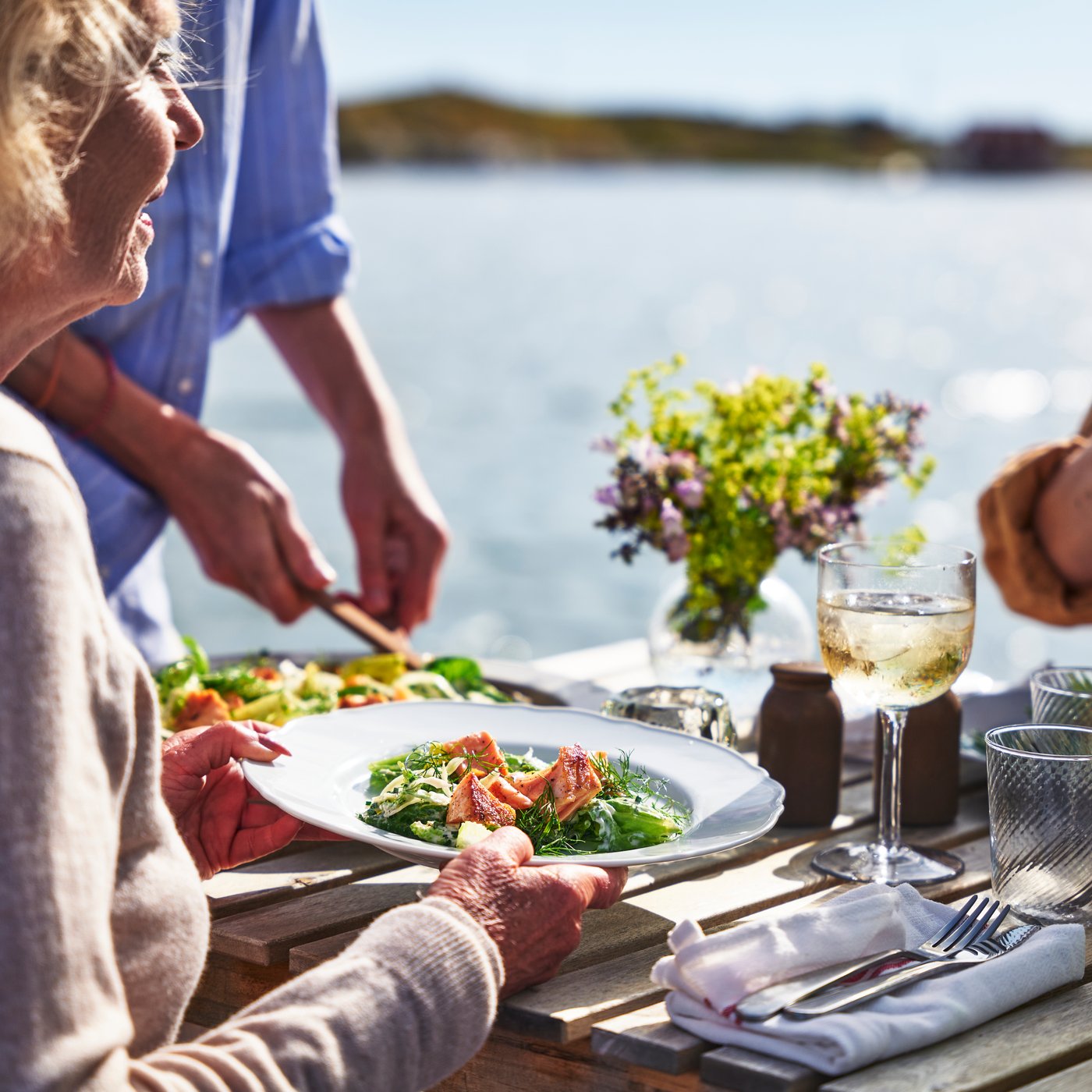 Family sitting waterfront sharing a meal