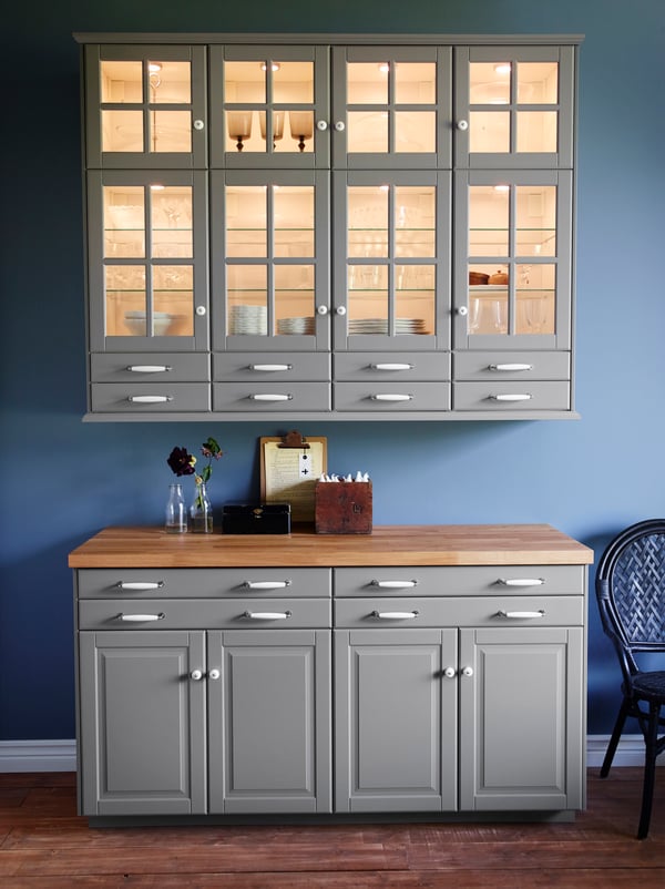 A grey kitchen with mouldings on the kitchen cabinets and classic handles.