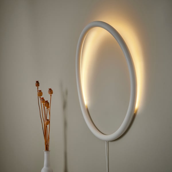 Una lampada circolare VARMBLIXT a LED appesa alla parete